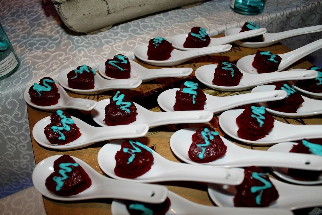 Plated dark chocolate mousse bites with teal drizzle, served on spoons